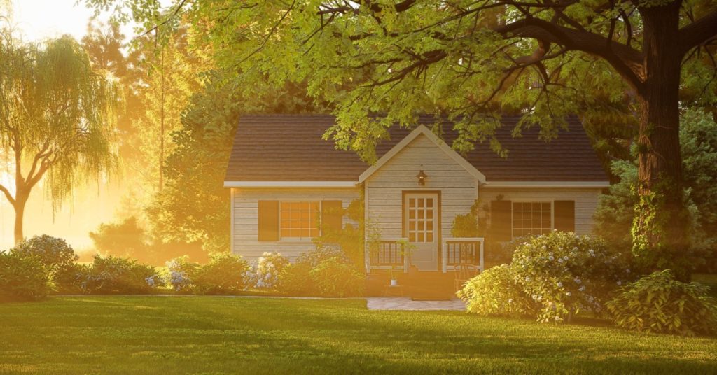 A small family home set back off the road a ways. The morning sun shines bright through the trees around the yard.